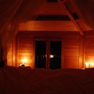 Cabane en bois cosy avec lumière tamisée et vue sur la nature. Parfait pour un séjour romantique.