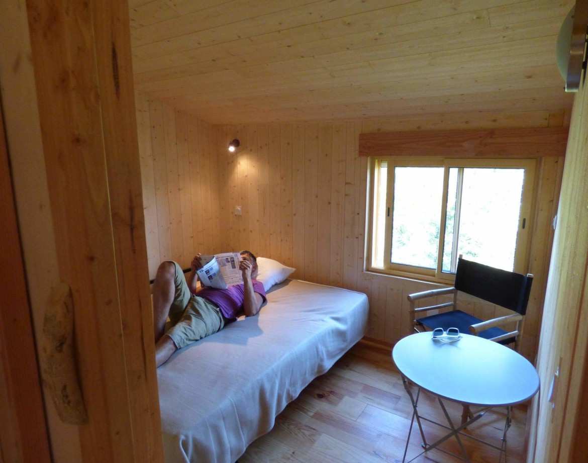 Cabane en bois cosy en Auvergne-Rhône-Alpes, avec vue sur la nature et mobilier simple.