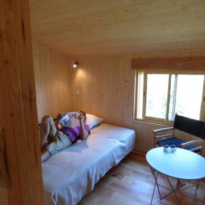 Cabane en bois cosy en Auvergne-Rhône-Alpes, avec vue sur la nature et mobilier simple.