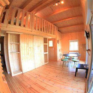 Chalet en bois chaleureux avec mezzanine et coin repas lumineux en Auvergne-Rhône-Alpes.