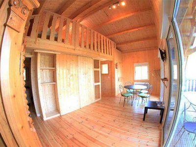 Chalet en bois chaleureux avec mezzanine et coin repas lumineux en Auvergne-Rhône-Alpes.