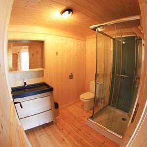 Salle de bain en bois dans un hébergement insolite en Auvergne-Rhône-Alpes.