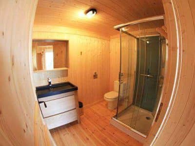Salle de bain en bois dans un hébergement insolite en Auvergne-Rhône-Alpes.