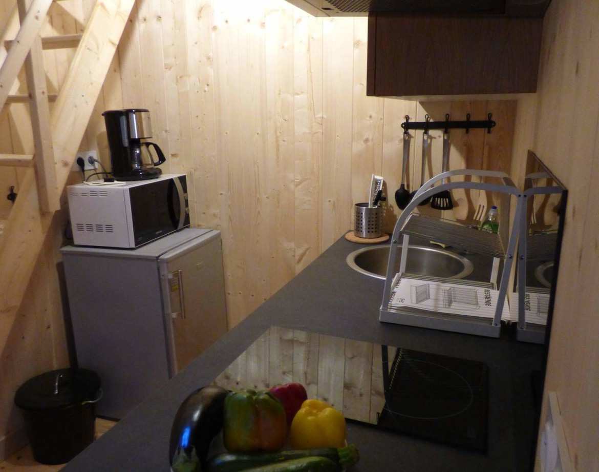 Hébergement insolite en Auvergne-Rhône-Alpes, cuisine moderne avec équipements en bois.
