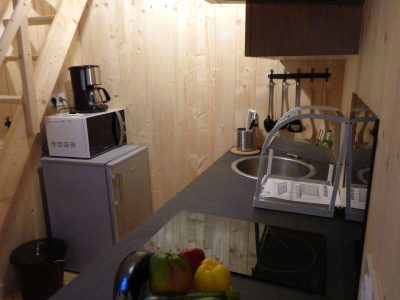 Hébergement insolite en Auvergne-Rhône-Alpes, cuisine moderne avec équipements en bois.