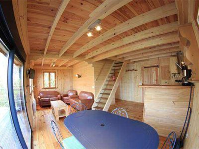 Intérieur chaleureux dun chalet en bois, avec salon et cuisine ouverte.