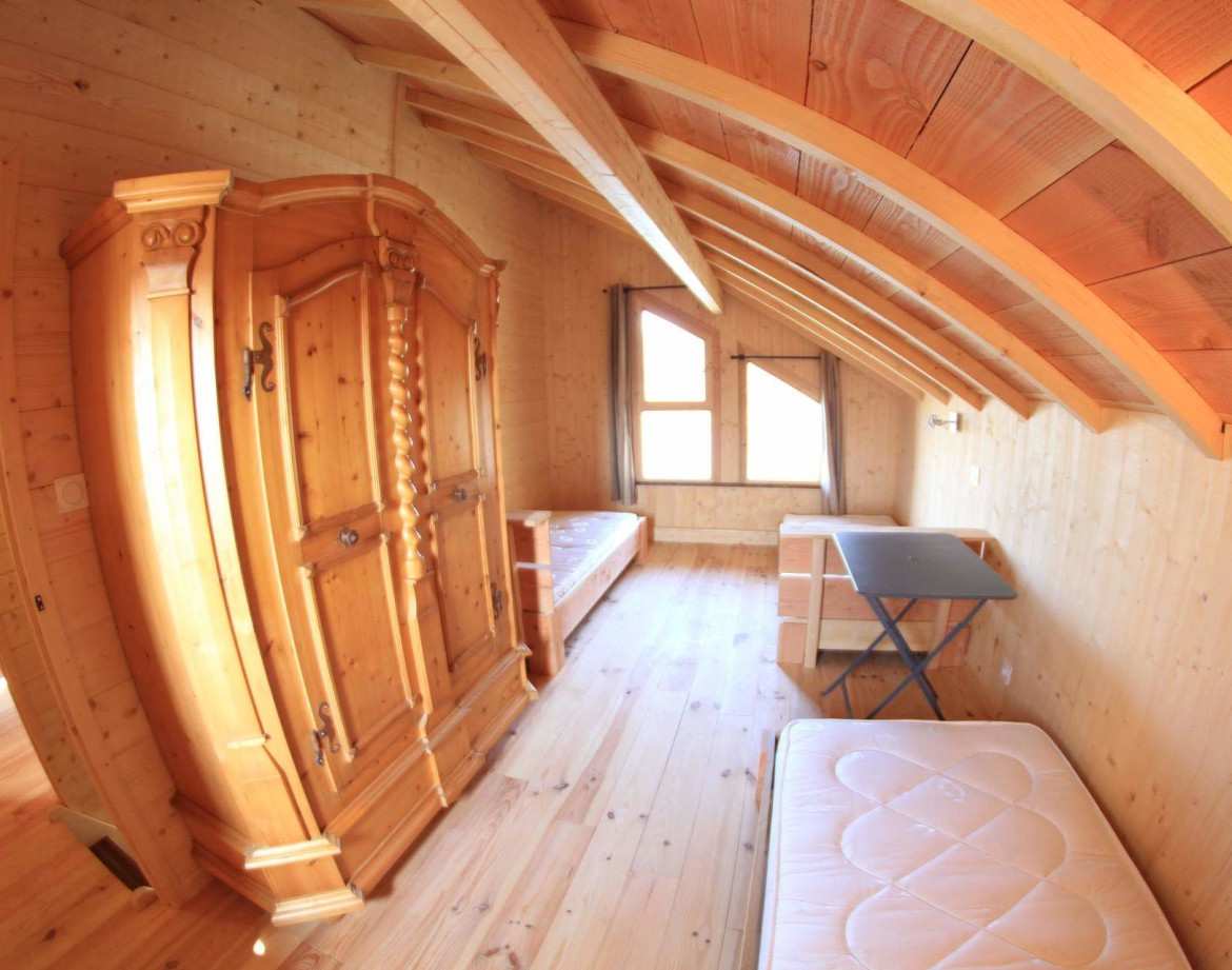 Chalet en bois chaleureux avec un mobilier rustique et une vue sur la nature.