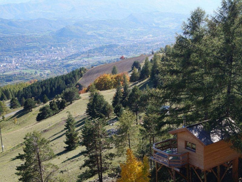Cabane perchée avec vue panoramique sur la vallée et les montagnes environnantes.