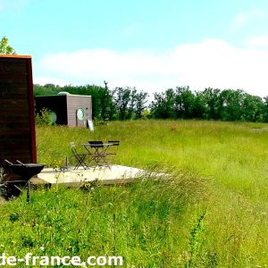 Cabanes modernes en pleine nature, entourées de verdure et avec terrasses privées.