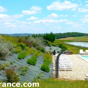 Cabane en bois avec piscine, entourée de verdure et de paysages apaisants.