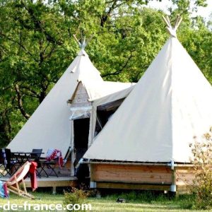 Tentes tipis spacieuses en pleine nature, avec terrasse et mobilier extérieur.