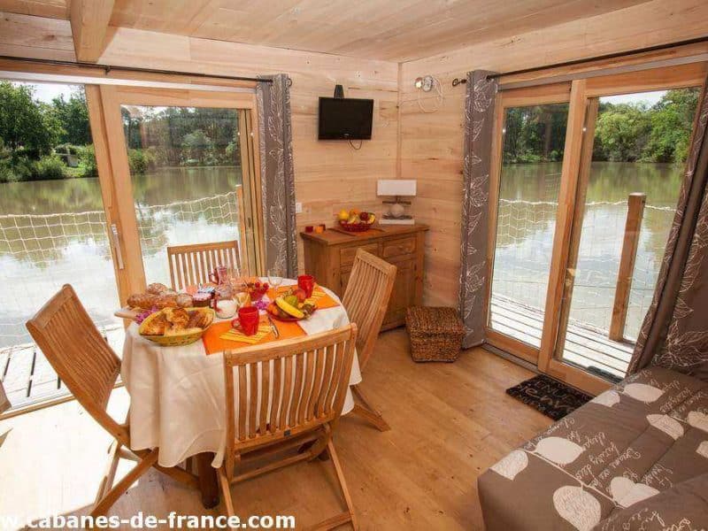 Cabane en bois avec vue sur le lac, décorée dune table conviviale.