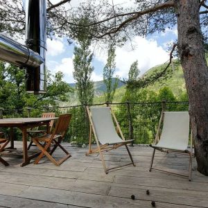 Cabane perchée en Auvergne-Rhône-Alpes avec terrasse en bois et vue sur la nature.