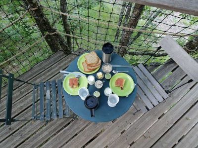 Table en bois avec petit-déjeuner dans une cabane perchée en Auvergne-Rhône-Alpes.