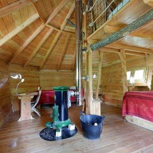 Cabane en bois chaleureuse avec poêle à bois et décoration rustique.