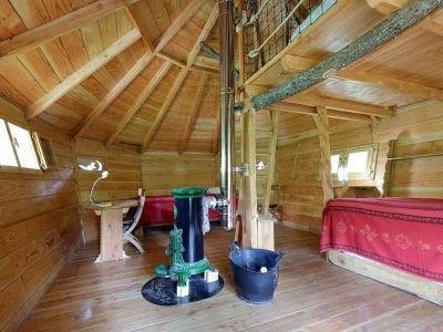 Cabane en bois chaleureuse avec poêle à bois et décoration rustique.
