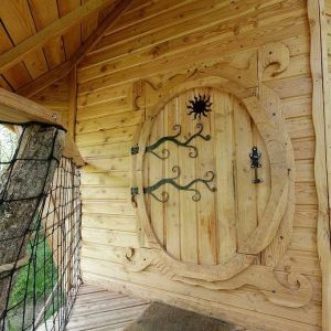 Cabane en bois avec une porte sculptée, nichée dans la nature en Auvergne-Rhône-Alpes.