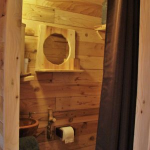 Cabane en bois avec un lavabo en pierre et des murs en bois naturel.