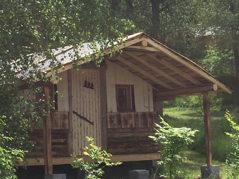 Charmante cabane en bois avec un toit en pente et un balcon accueillant.