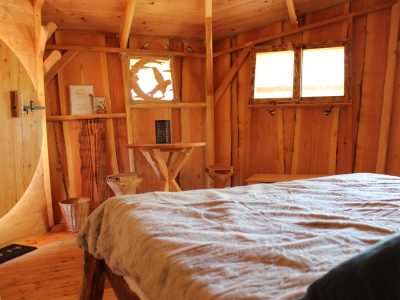 Cabane en bois cosy avec lit douillet et décor naturel en Provence-Alpes-Côte dAzur.