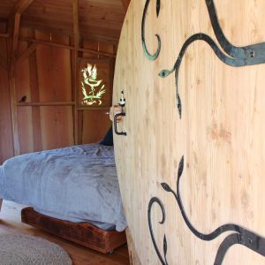 Hébergement insolite en bois avec porte ronde et intérieur chaleureux en Provence-Alpes-Côte dAzur.