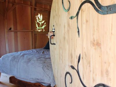 Hébergement insolite en bois avec porte ronde et intérieur chaleureux en Provence-Alpes-Côte dAzur.