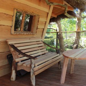 Cabane en bois avec terrasse, banc en bois et vue sur la nature en Provence-Alpes-Côte dAzur.