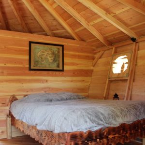 Cabane en bois dans les Alpes, lit douillet et ambiance chaleureuse.