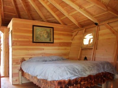 Cabane en bois dans les Alpes, lit douillet et ambiance chaleureuse.