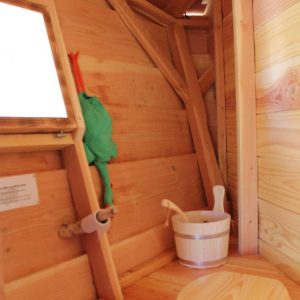 Cabane en bois avec intérieur chaleureux et seau en bois pour un séjour unique.