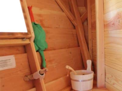 Cabane en bois avec intérieur chaleureux et seau en bois pour un séjour unique.