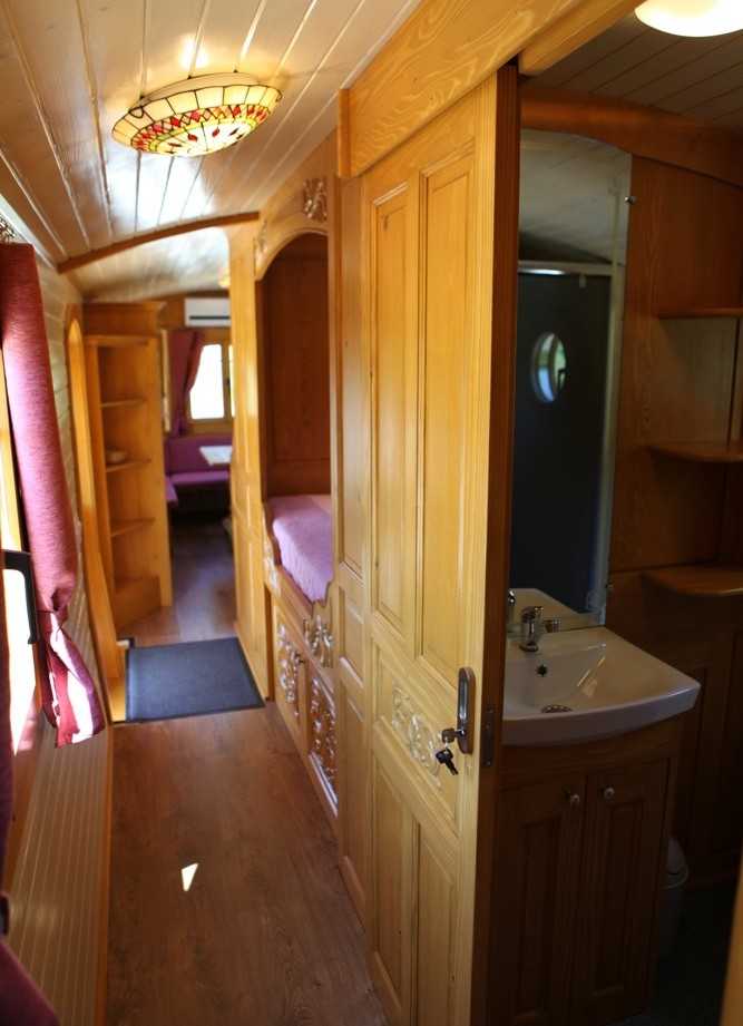 Intérieur dun hébergement insolite en Auvergne-Rhône-Alpes, avec bois chaleureux et salle de bain.
