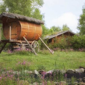 Hébergement insolite en Auvergne : roulotte en bois entourée de fleurs sauvages.