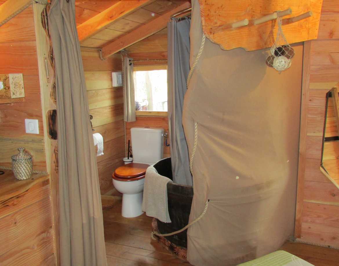 Cabane en bois en Bretagne avec salle de bain et décoration chaleureuse.