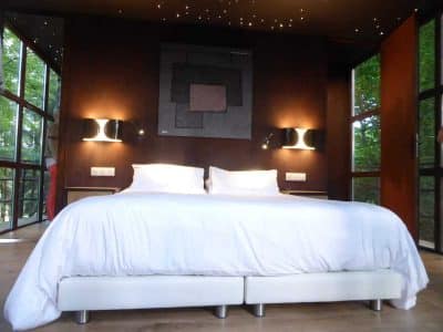 Chambre moderne en cabane avec vue sur la nature et éclairage étoilé.