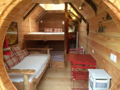 Hébergement insolite en tonneau en bois, avec lit superposé et décoration chaleureuse.