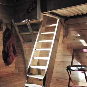Cabane en bois avec échelle, ambiance chaleureuse et naturelle. Parfait pour un séjour insolite.