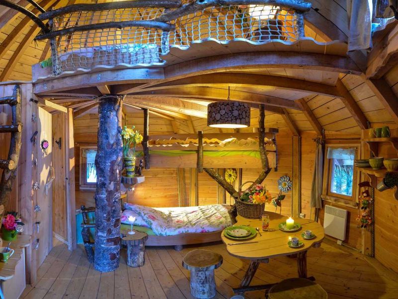 Cabane en bois chaleureuse avec mezzanine et décor floral accueillant.