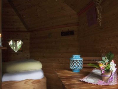 Cabane en bois cosy en Auvergne, décorée avec une lampe turquoise et des fleurs.