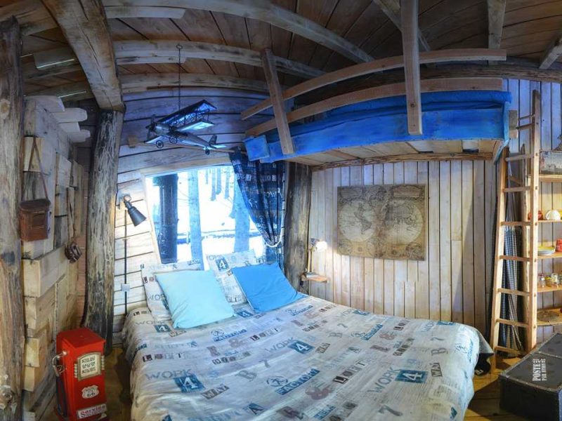 Chalet en bois chaleureux avec lit douillet et décoration rustique.