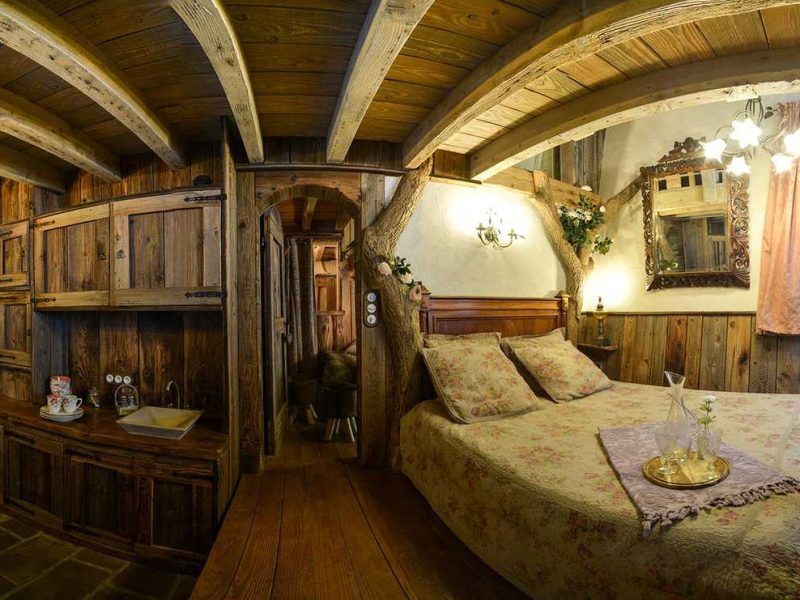 Chalet en bois chaleureux avec un lit douillet et une table rustique.
