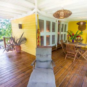 Hébergement insolite en bois à Outre-Mer, avec terrasse en bois et décoration tropicale.