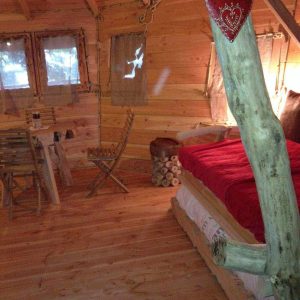 Cabane en bois à Bourgogne, intérieur chaleureux avec lit douillet et décor naturel.