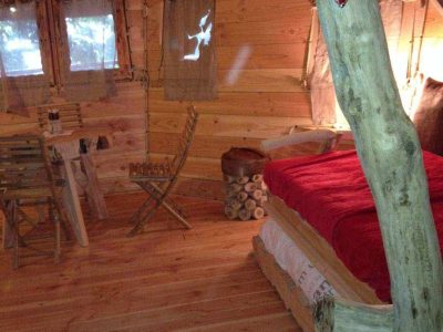 Cabane en bois à Bourgogne, intérieur chaleureux avec lit douillet et décor naturel.