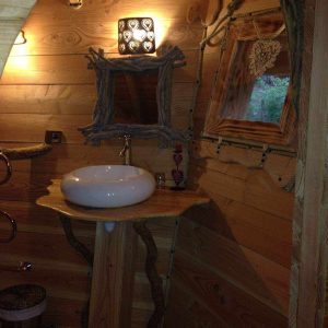 Cabane en bois en Bourgogne, avec lavabo en bois et décor naturel chaleureux.