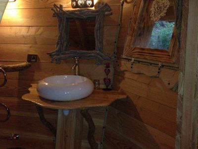 Cabane en bois en Bourgogne, avec lavabo en bois et décor naturel chaleureux.