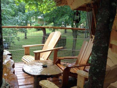 Cabane perchée en Bourgogne avec terrasse en bois et chaises confortables.