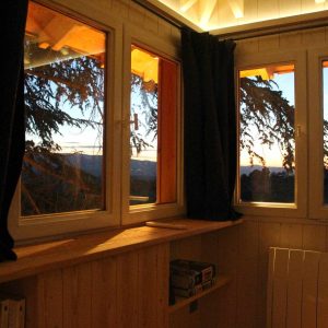 Cabane perchée en Auvergne-Rhône-Alpes, vue panoramique sur le coucher de soleil.