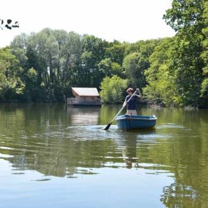 Cabane flottante dans les Pays de la Loire, vue paisible sur un lac verdoyant.