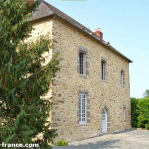 Maison en pierre typique du Pays de la Loire, entourée de verdure apaisante.